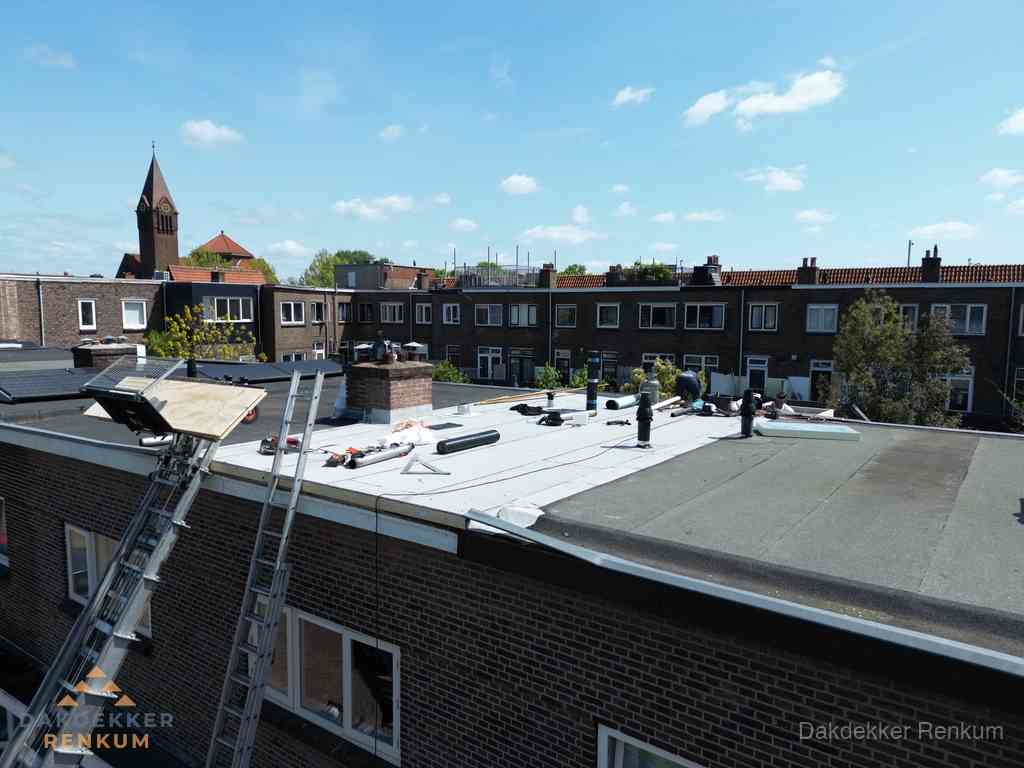 Dakdekkers aan het werk op plat dak in Renkum
