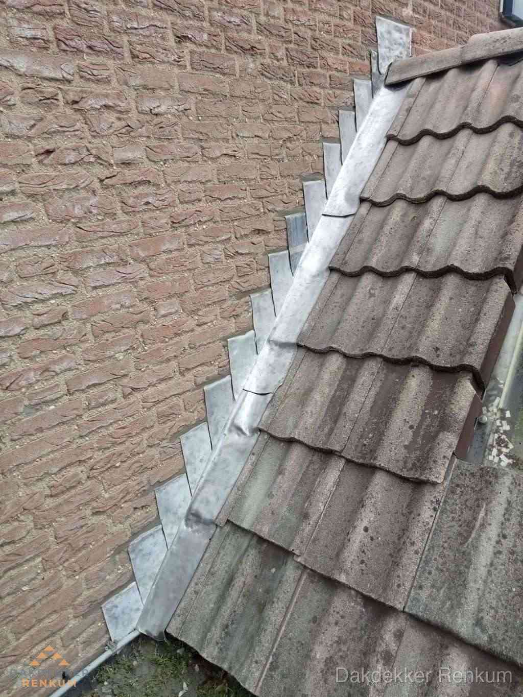 Loodslabben langs dakaansluiting bij bakstenen muur in Renkum
